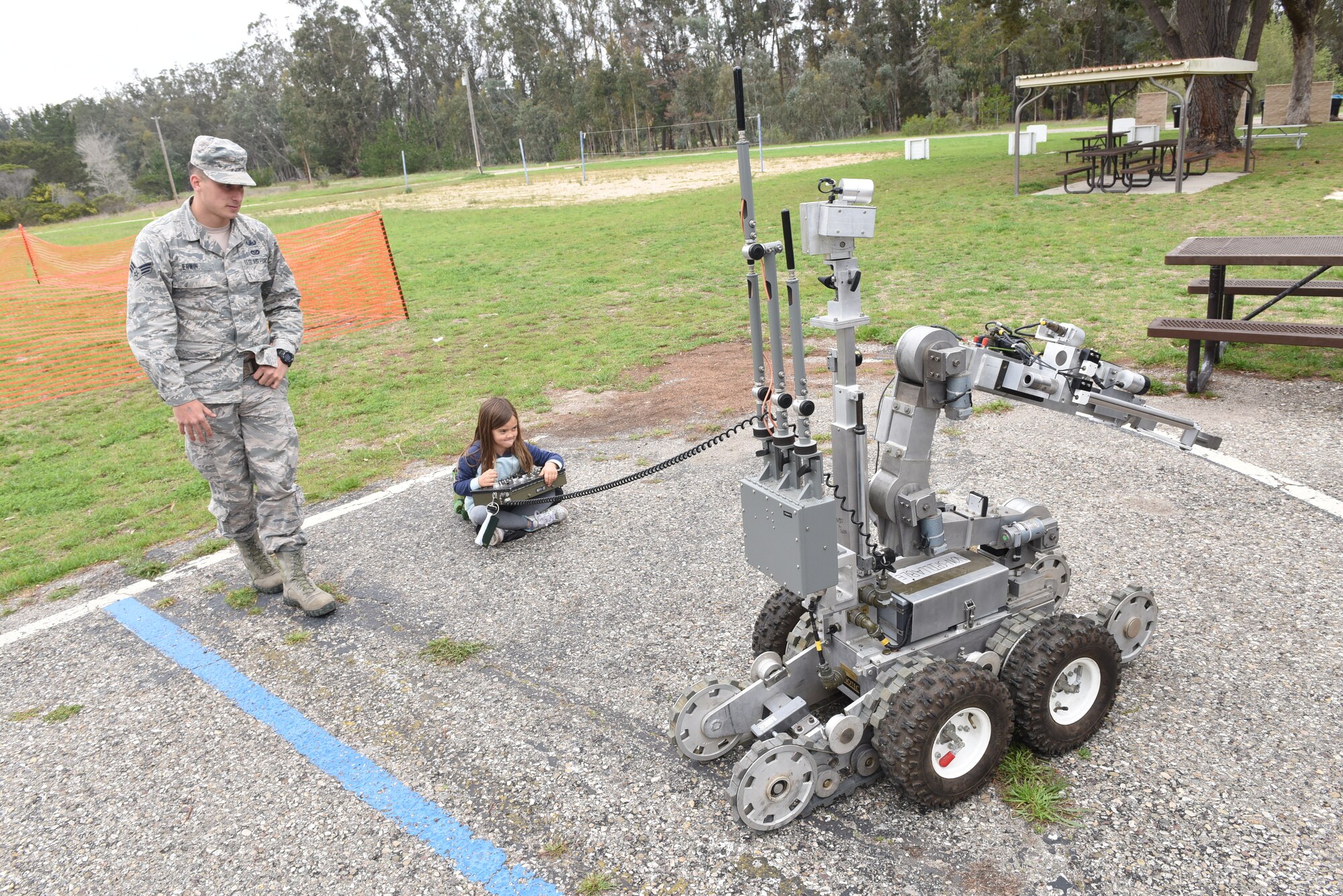 Senior Airman Tyler Erwin, 30th Civil Engineer Squadron explosive ordnance disposal specialist, assists a military child with an EOD robot during Kids Understanding Deployment Operations, April 4, 2018, Vandenberg Air Force Base, Calif. KUDOS is a program developed to give children a deeper understanding of the military deployment process and equipment utilized during a deployment. (U.S. Air Force photo by Tech. Sgt. Jim Araos/Released)