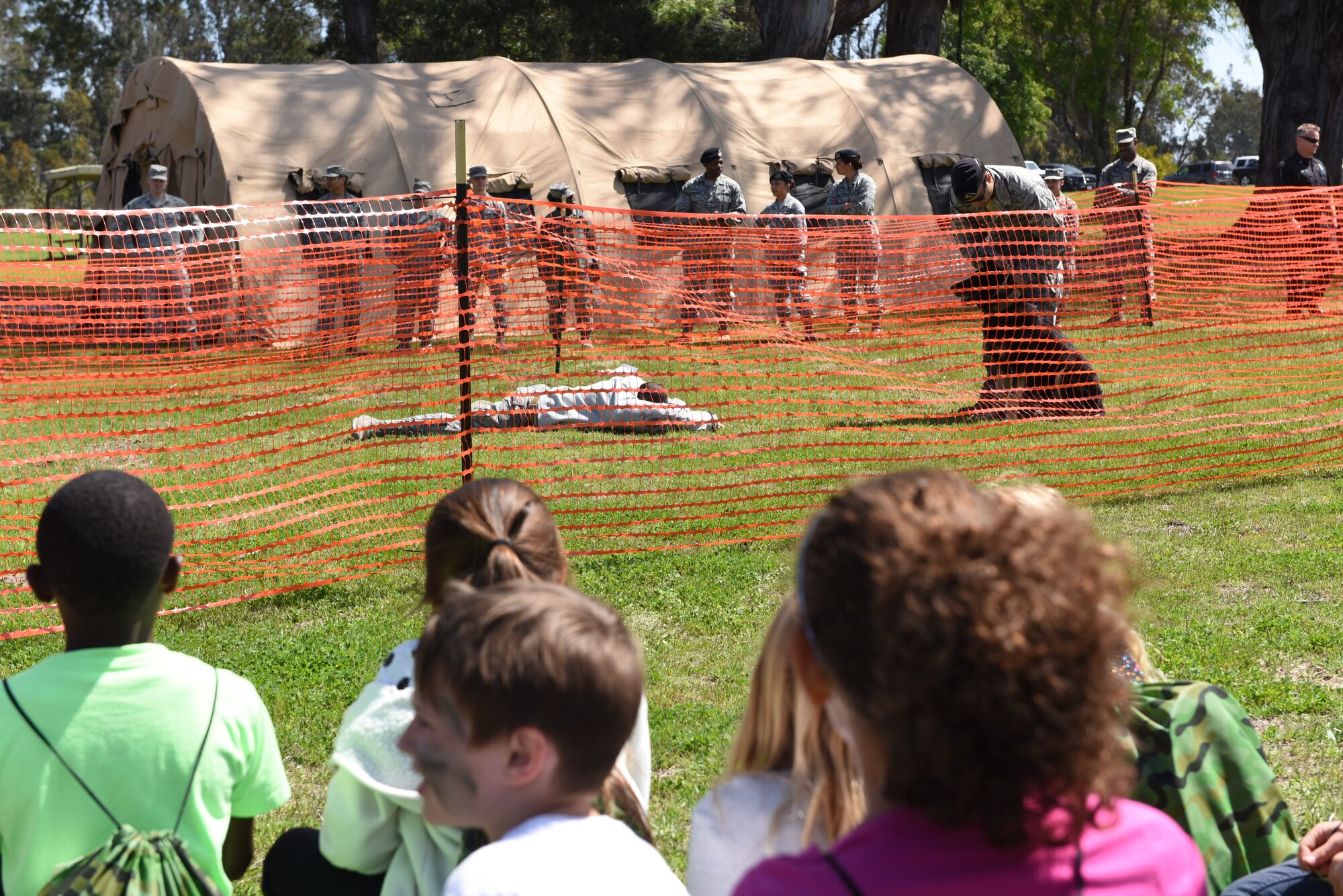 The 30th Security Forces Squadron military working dog handlers perform a demonstration during Kids Understanding Deployment Operations, April 4, 2018, Vandenberg Air Force Base, Calif. KUDOS is a program developed to give children a deeper understanding of the military deployment process and equipment utilized during a deployment. (U.S. Air Force photo by Tech. Sgt. Jim Araos/Released)
