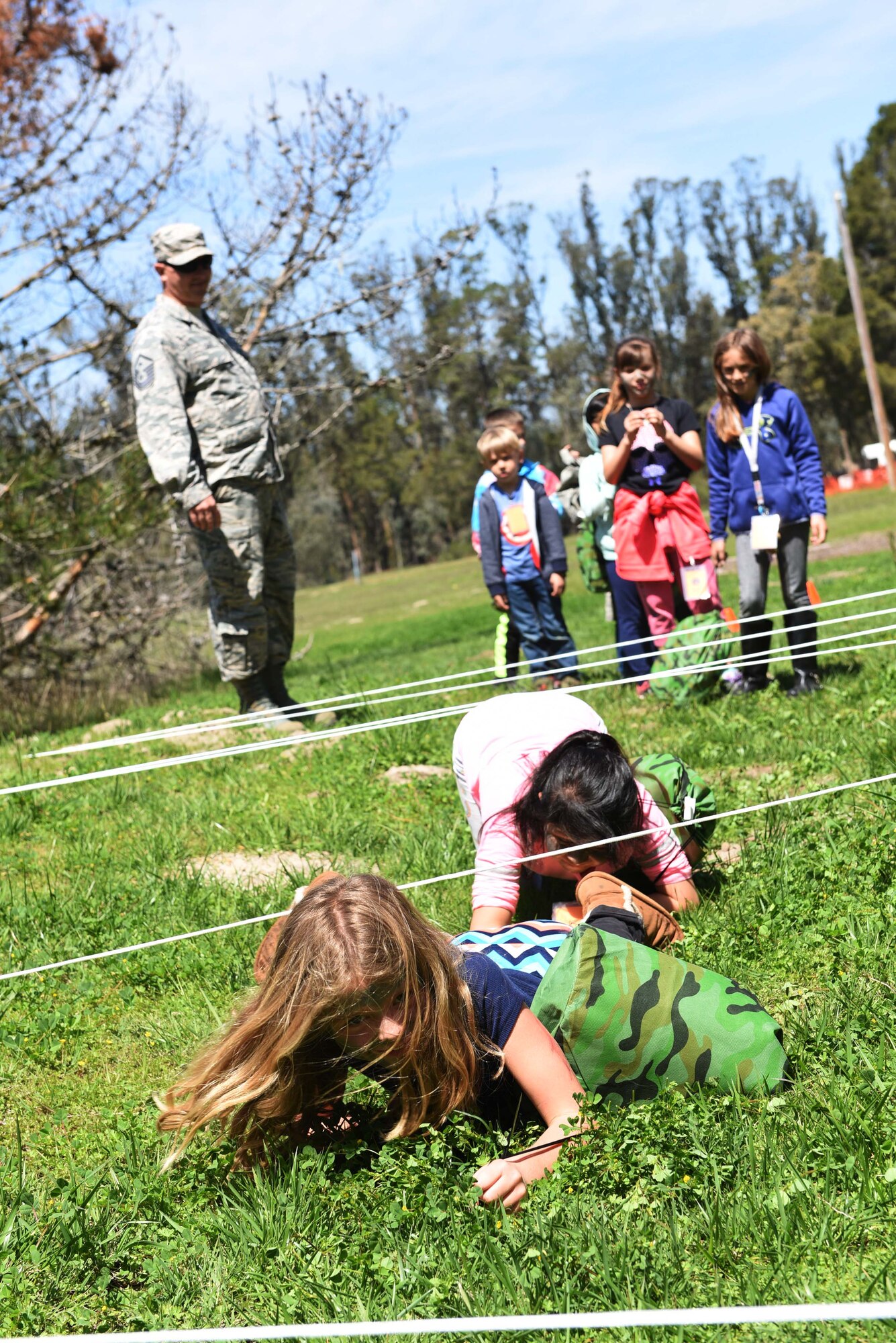 Military children low crawl through an obstacle course during Kids Understanding Deployment Operations, April 4, 2018, Vandenberg Air Force Base, Calif. KUDOS is a program developed to give children a deeper understanding of the military deployment process and equipment utilized during a deployment. (U.S. Air Force photo by Tech. Sgt. Jim Araos/Released)