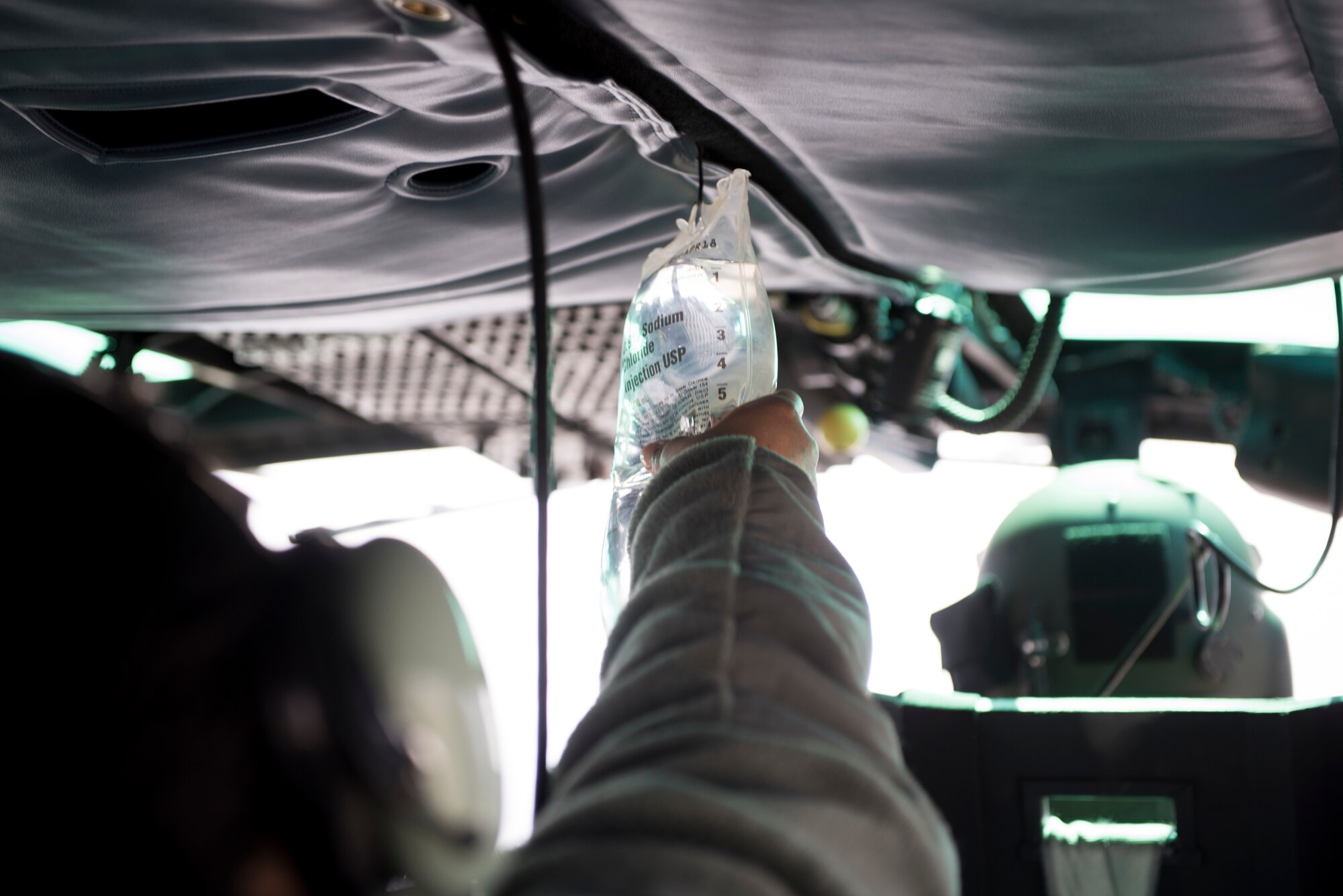 A 374th Medical Group nurse checks IV bag during a patient transfer training flight in a 459th Airlift Squadron UH-N1 Iroquois, March 30, 2018, at Yokota Air Base, Japan.