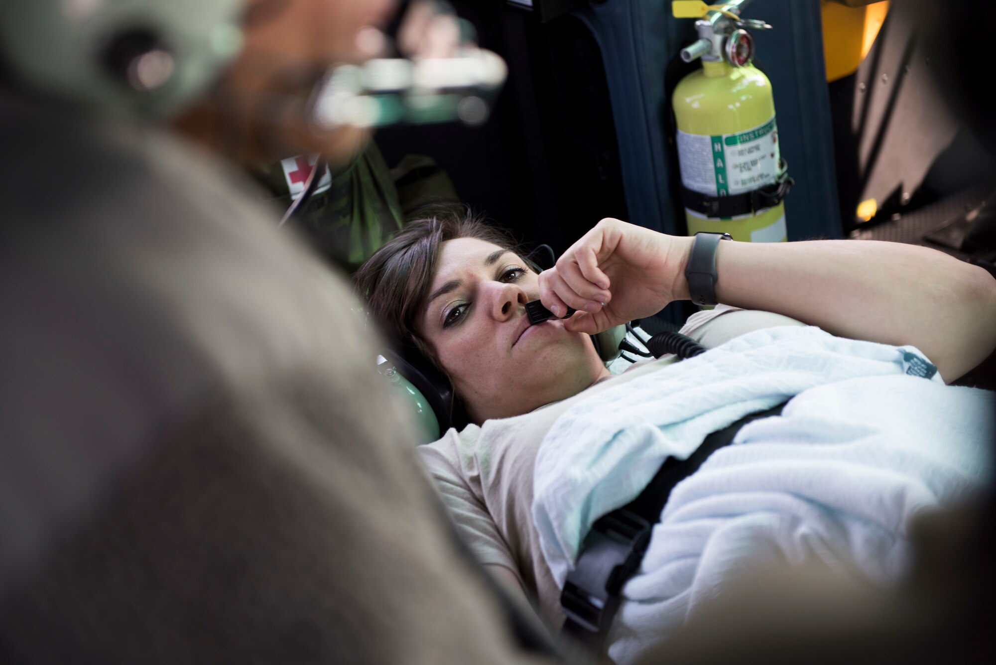 2nd Lt. Tera Hammond, 374th Medical Group clinical nurse and simulated patient, listens to aircrew during patient transfer training in a UH-N1 Iroquois, March 30, 2018, near U.S. Fleet Activities Yokosuka, Japan.