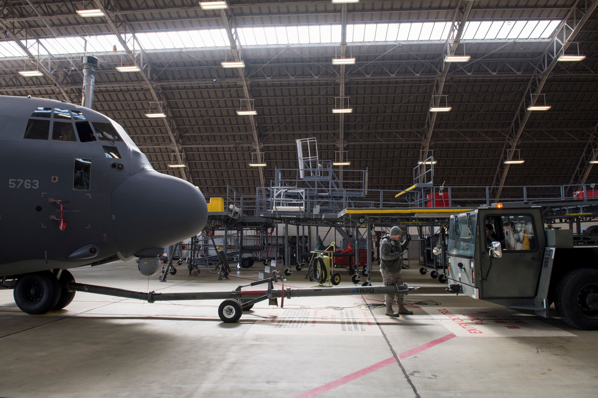 An Airman with the 374th Maintenance Squadron guides an aircraft towing vehicle into place, Feb. 27, 2018, at Yokota Air Base, Japan.