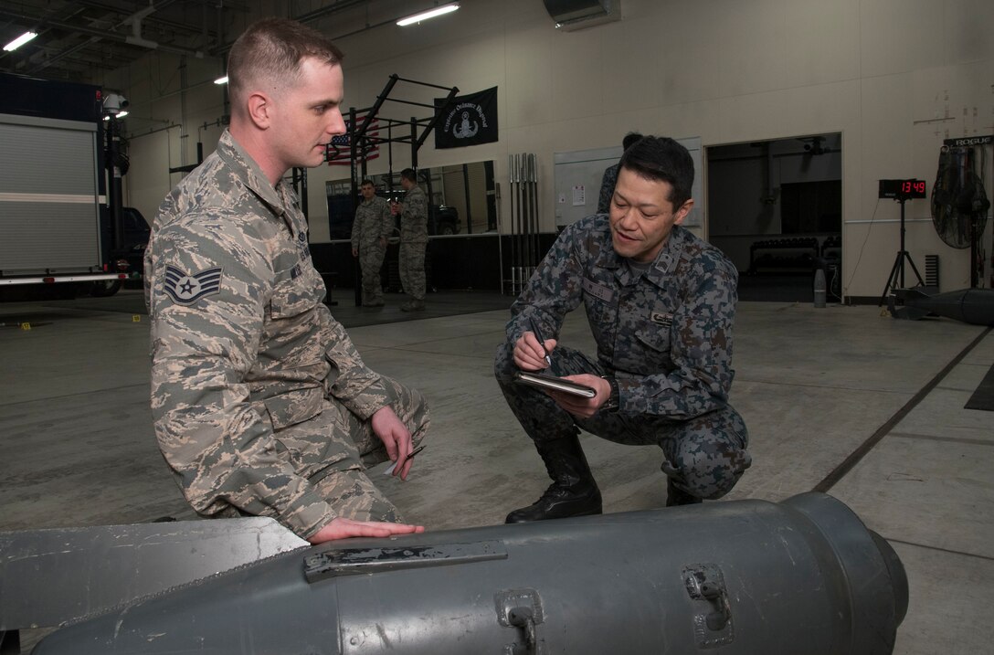 U.S. Air Force Staff Sgt. Kyle Miller, left, the 35th Civil Engineer Squadron explosive ordnance
disposal NCO in charge, explains the makeup of a Russian bomb to Japan Air Self-Defense
Force Master Sgt. Tomomune Segawa, a Tohoku EOD School instructor, at Misawa Air Base,
Japan, March 29, 2018. Tohoku instructors attended the course in order to better their ordnance
disposal skills for future bilateral missions. Once complete, the instructors took their newly
gained knowledge and delivered it to their units. (U.S. Air Force photo by Senior Airman Sadie
Colbert)