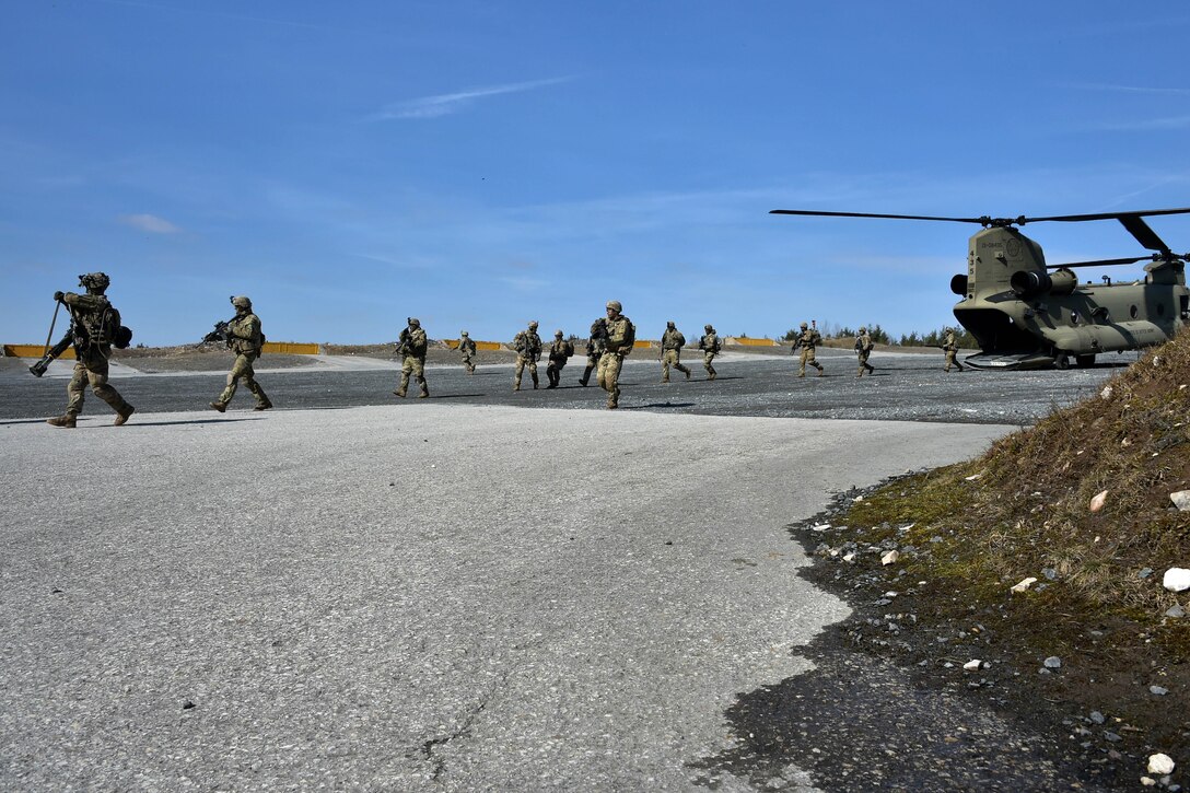 Soldiers offload from a CH-47 Chinook helicopter.