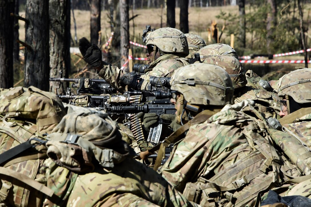Soldiers prepare to fire their automatic weapons at targets.