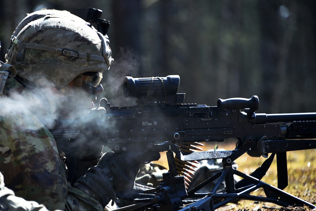 A soldier fires his machine gun at targets.