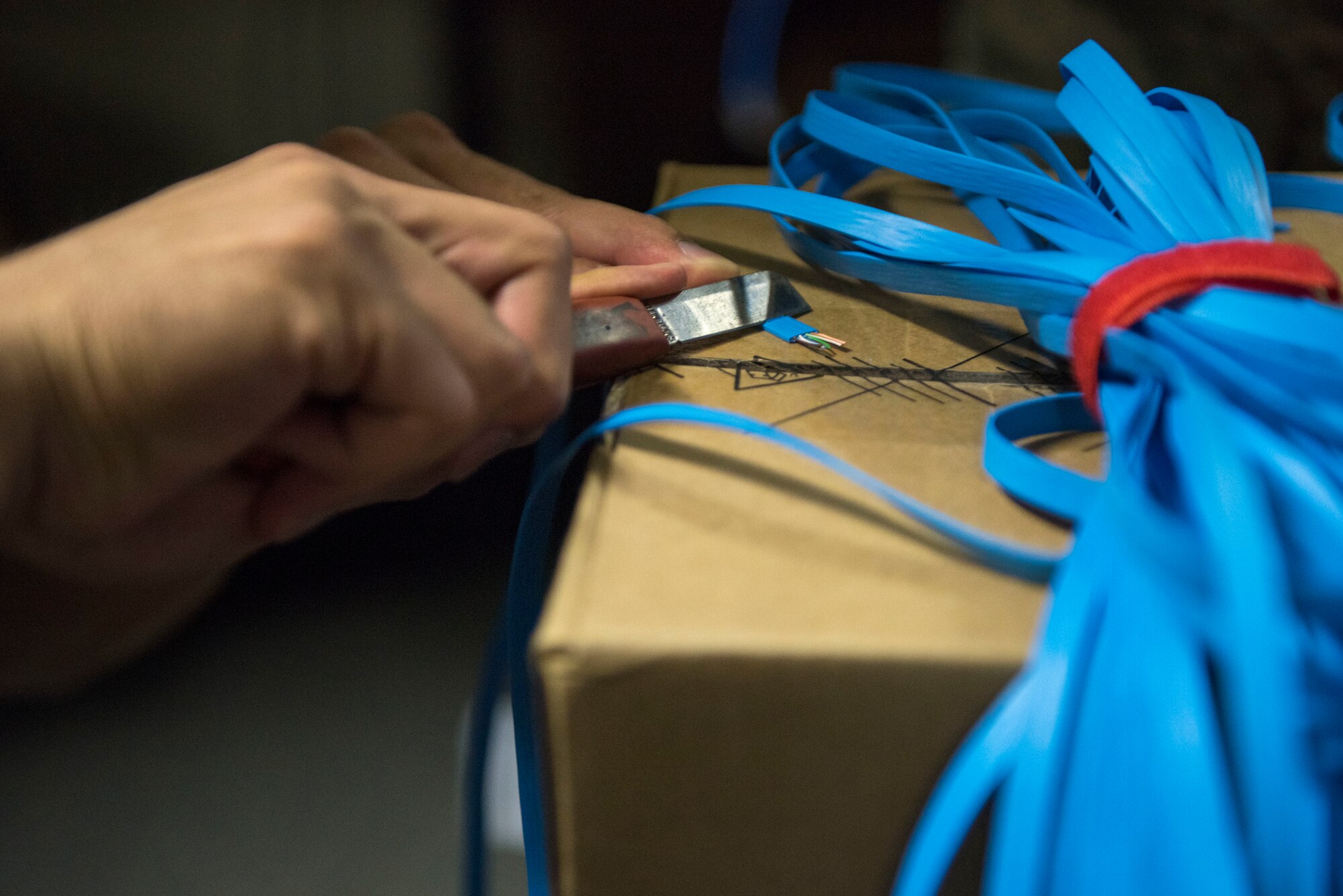 Airman 1st Class Andrews De Leon, 374th Communications Squadron Operations Flight client systems technician apprentice, removes excess wire prior to attaching a clip at Yokota Air Base, Japan, April 4, 2018.