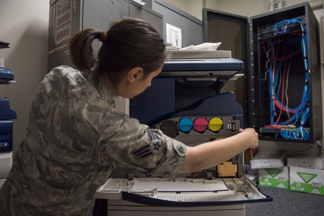 Senior Airman Amy Kristoffersen, 374th Communications Squadron Operations Flight client systems technician journeyman, opens up the side of a printer prior to performing a printer swap at Yokota Air Base, Japan, April 4, 2018.