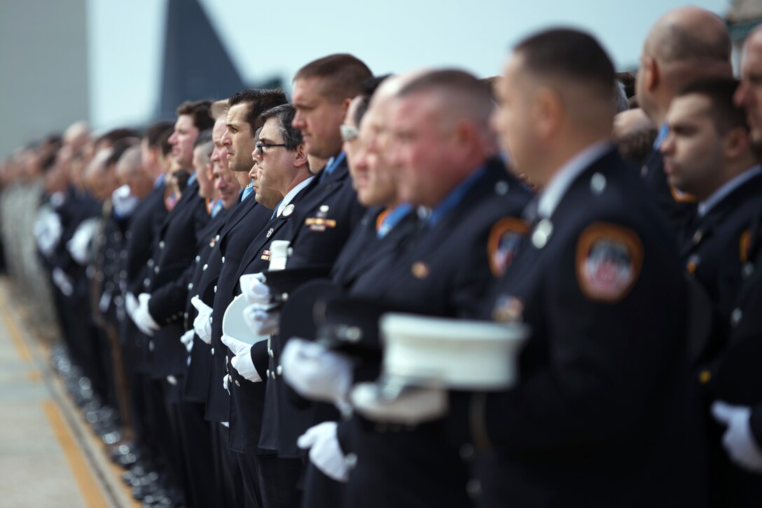 Airmen and members of local fire departments render honors.