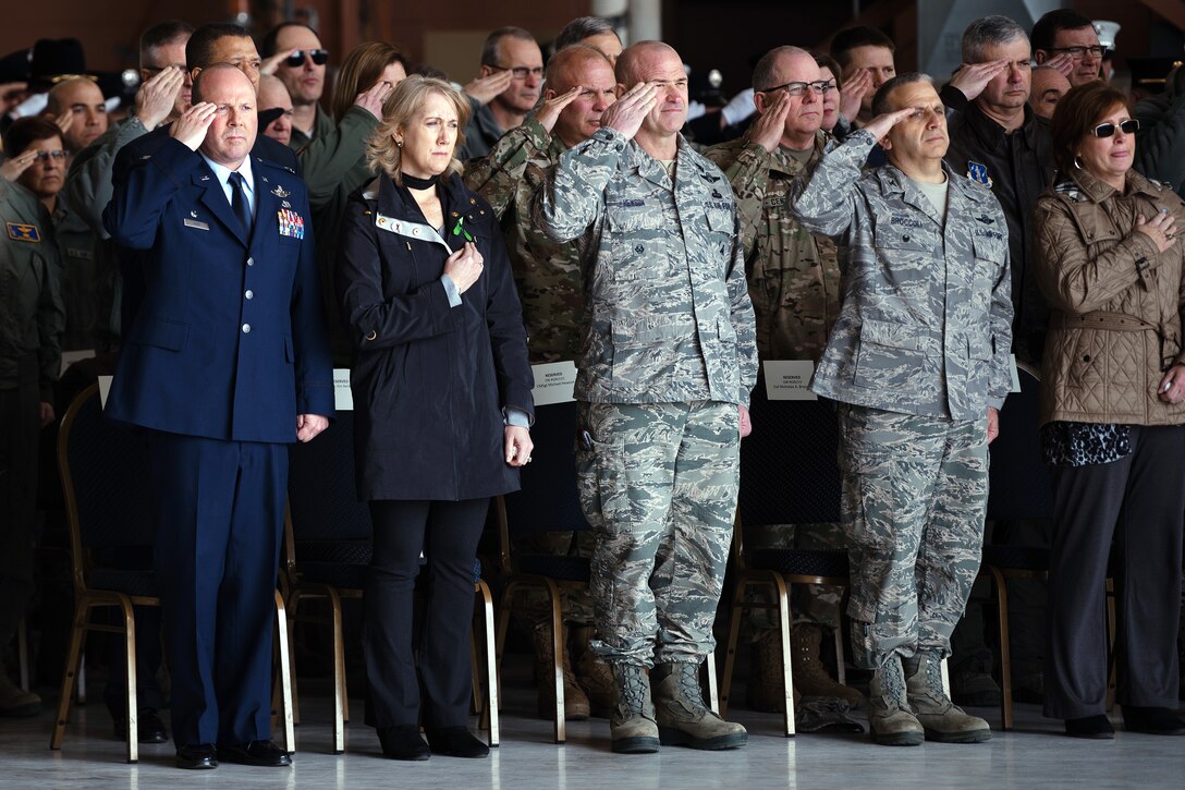 Airmen and civilians salute during a dignified arrival.