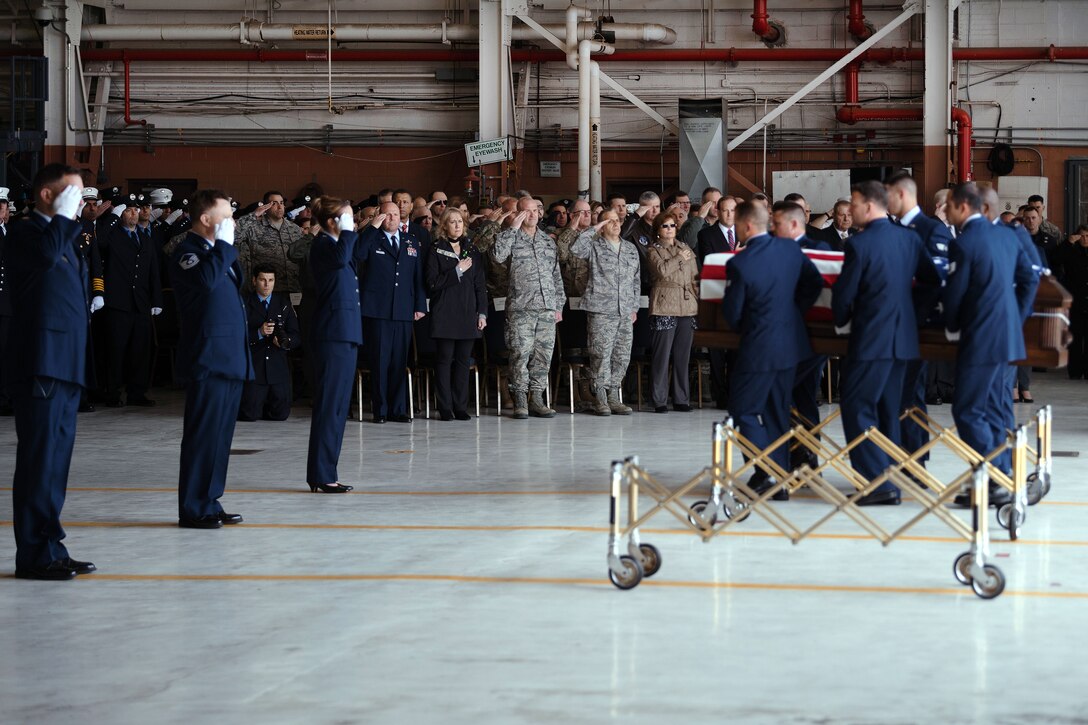 Airmen carry a flag-covered coffin.