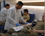 John Whitfield, medical laboratory technician with the Akeroyd Blood Donor Center, prepares to collect blood from Army Pvt. William Mulroney (foreground) while LaTonya Steward preps Army Pvt. Anthony Rosado. Both Soldiers are assigned to CompanyE, 232nd Medical Battalion.