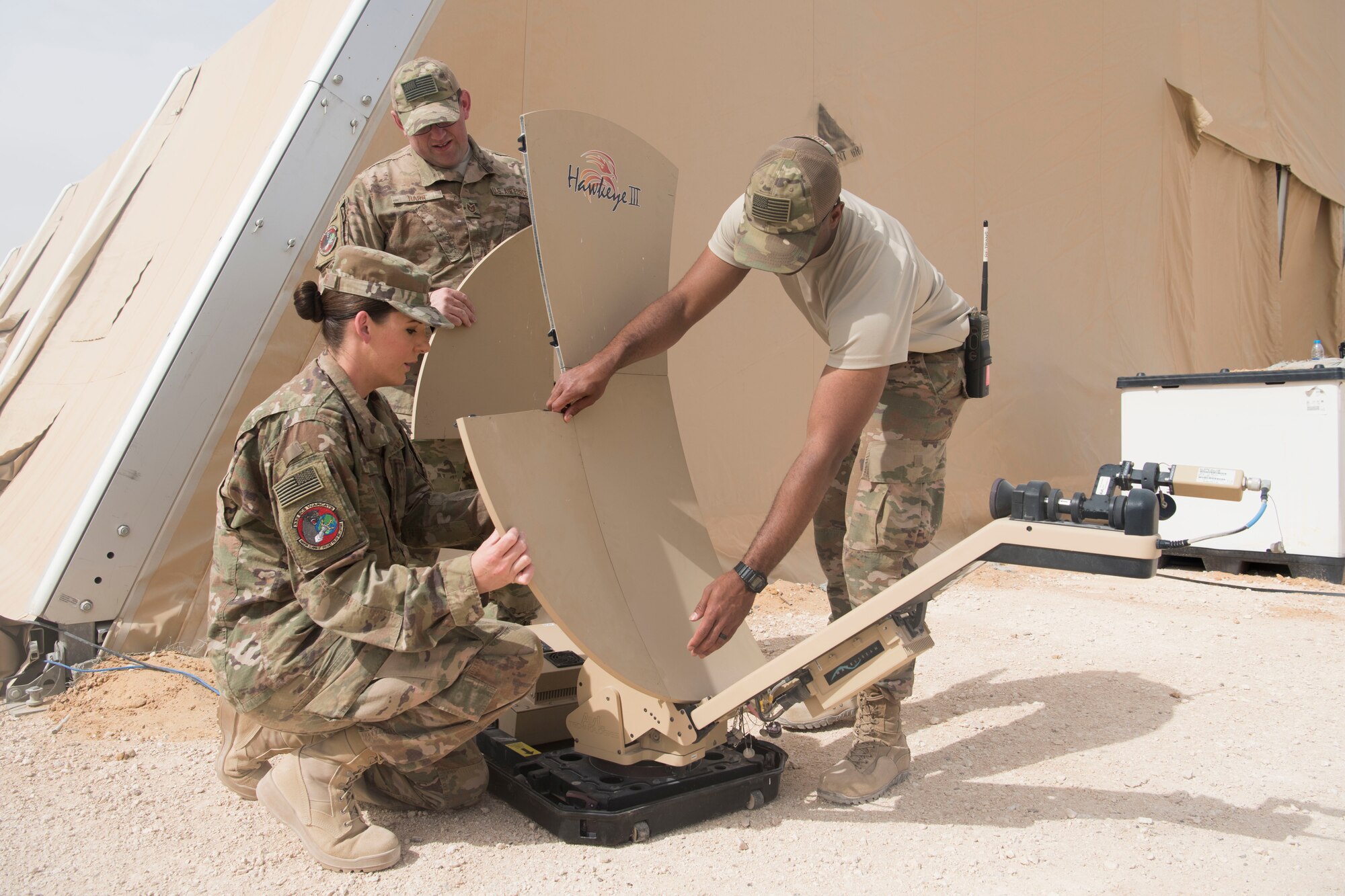 Airman 1st Class Branda Fanning (left) and Staff Sgt. Malcom Monroe (right), 332nd Expeditionary Communications Squadron radio frequency transmission technicians, along with Tech. Sgt. Brad Harr (middle), 332nd ECS NCO in charge of the radio frequency transmission section, set up a 1.2 meter satellite as part of an exercise March 22, 2018, at an undisclosed location in Southwest Asia.