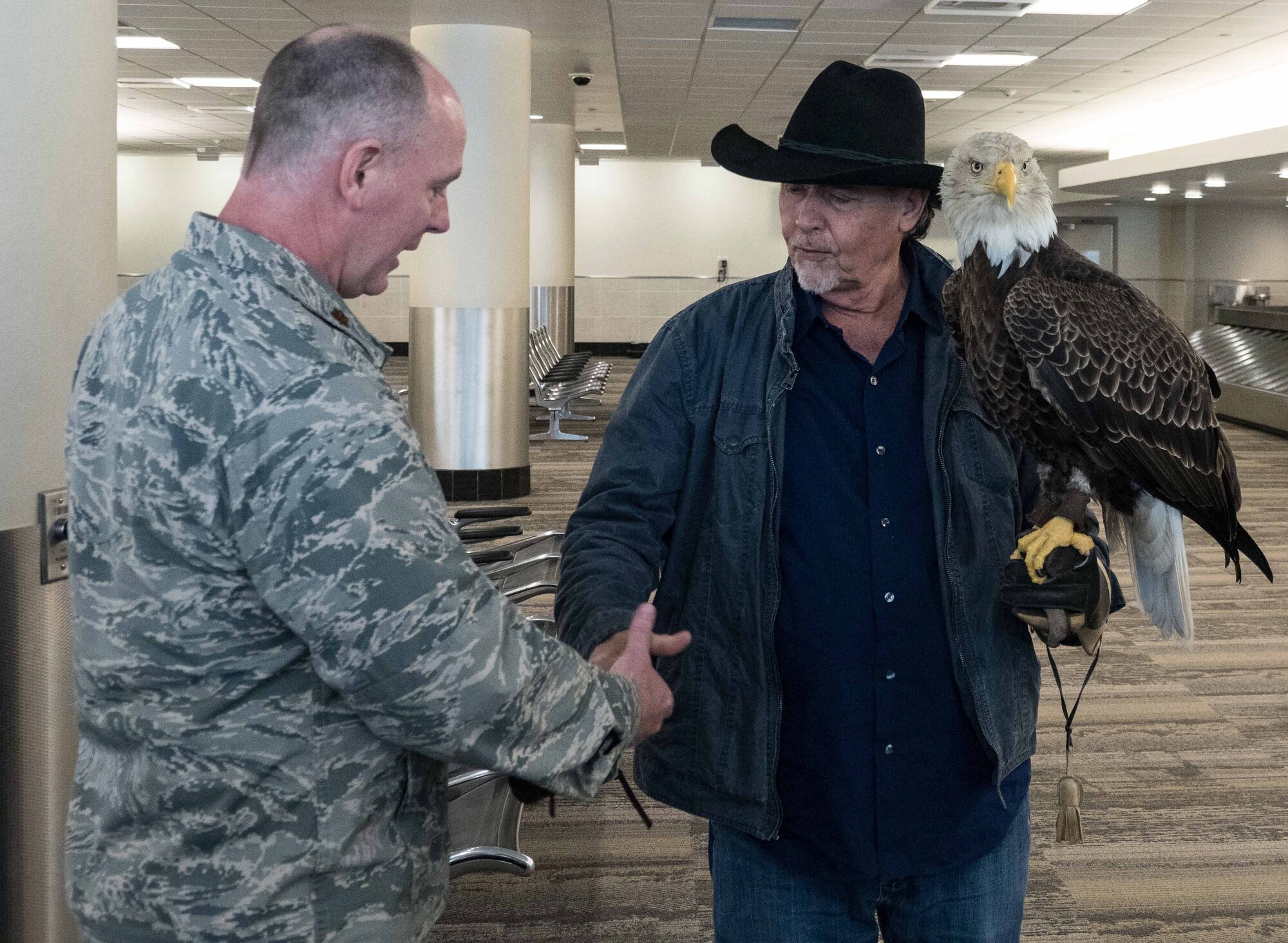 Maj. Pat McDonald, 934th Communications Squadron commander, greets Al Louis Cecere, Founder and President of the American Eagle Foundation, and Challenger the Eagle at the Minneapolis-St. Paul International Airport April 4.  Challenger will fly during the national anthem at the Minnesota Twins opening day April 5. (Air Force Photo/Paul Zadach)