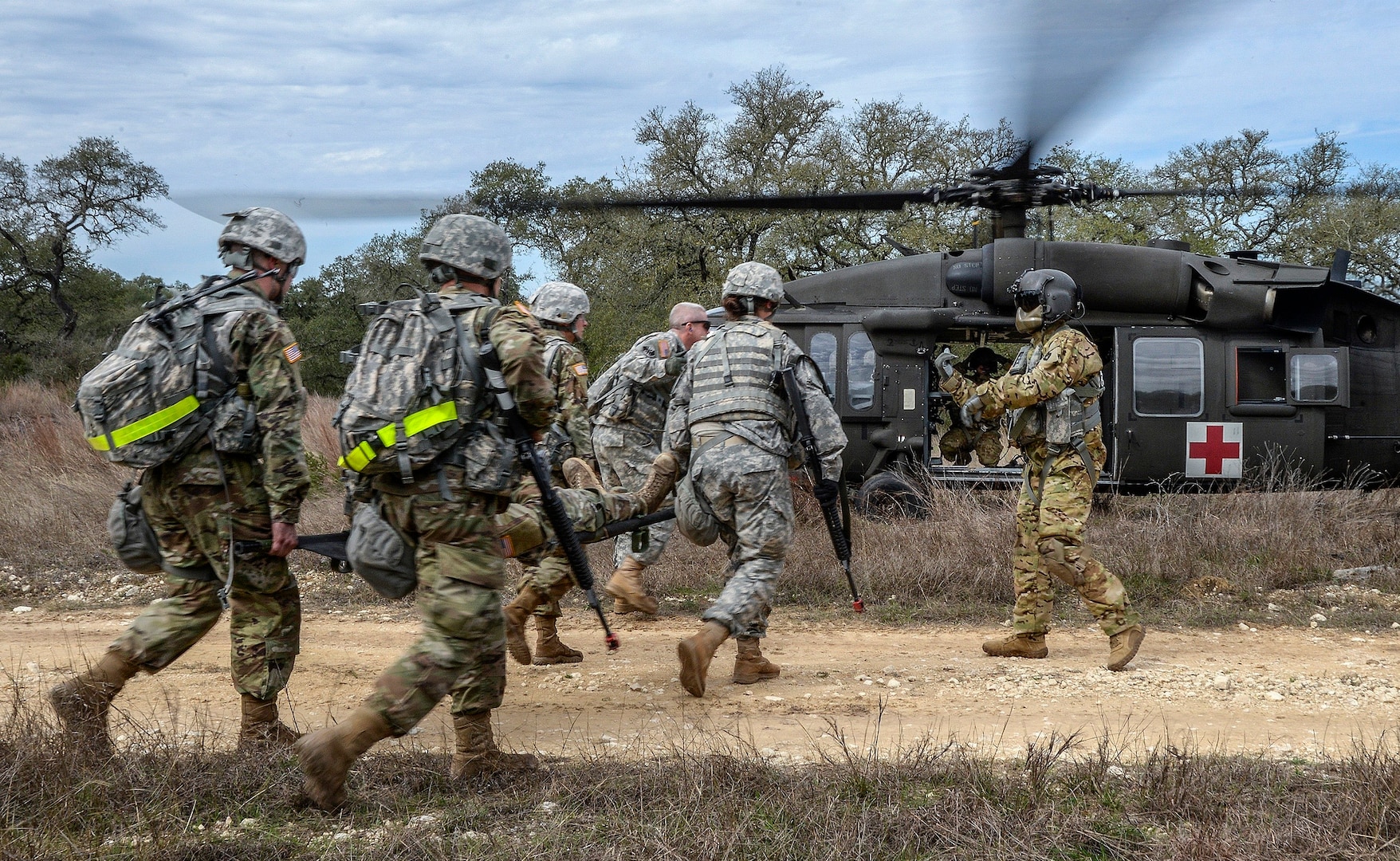 Students in the U.S. Army Medical Department Center and School Basic Officer Leader Course, or BOLC, carry a “wounded” service member on a stretcher towards a helicopter that will evacuate and transport the patient to a medical facility during a simulated tactical exercise February 26 at Joint Base San Antonio-Camp Bullis. The students, who are incoming commissioned Army officers, learned how to treat, move and transport wounded and injured service members in simulated combat settings, including a convoy that is ambushed and damaged by an improvised explosive device. BOLC is the entry level course for students who are becoming commissioned officers in the Army and is conducted in two phases over seven weeks, including classroom training and field training. The objective of the course is to train new officers in Army tasks and familiarize them with the AMEDD culture.