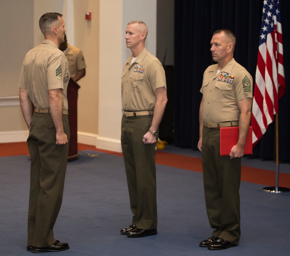 Sergeant Kenneth Newton, left, the 37th Color Sergeant of the Marine Corps, receives an award from Col. Tyler J. Zagurski, center, commanding officer, Marines Barracks Washington D.C., during the Color Sergeant of the Marine Corps relief and appointment ceremony at the Barracks, April 6, 2018. Newton, a Colorado Springs, Colorado native, previously served as an infantry machine gunner with 1st battalion, 4th Marine Regiment and will return to the operating forces once he departs the Barracks.(Official U.S. Marine Corps photo by Pfc. James Bourgeois/Released)