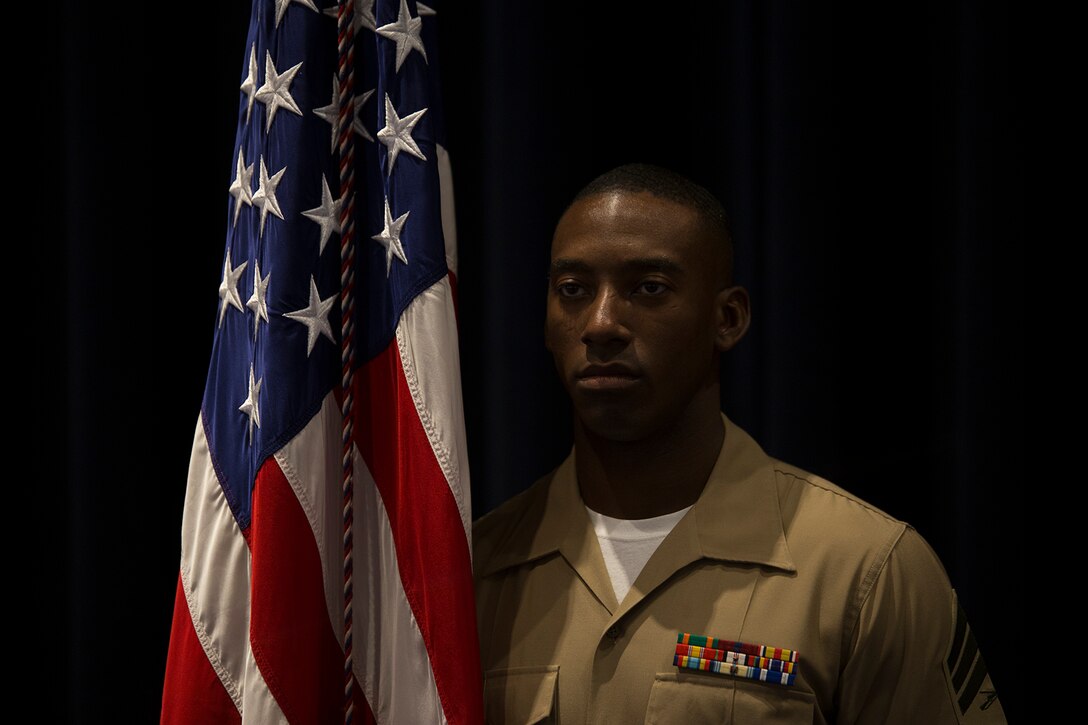 The 38th Color Sergeant of the Marine Corps, Sgt. Francis Frazier, poses for a photo next to the National Ensign, at the conclusion of a relief and appointment ceremony at Marine Barracks Washington D.C., April 6, 2018. The Color Sergeant of the Marine Corps serves as the senior Sergeant of the Corps, entrusted with carrying the National Ensign in ceremonies throughout the National Capitol Region and across the nation. The Color Sergeant leads the official Color Guard Platoon at MBW and is responsible for training and preparing the Marines for future service in the operating forces. (Official U.S. Marine Corps photo by Pfc. James Bourgeois/Released)