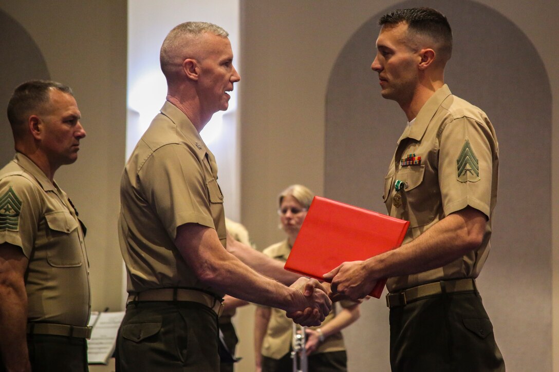 Colonel Tyler J. Zagurski, center, commanding officer, Marine Barracks Washington D.C., awards a Navy Commendation medal to Sgt. Kenneth Newton, the 37th Color Sergeant of the Marine Corps, during the Color Sergeant of the Marine Corps relief and appointment ceremony at Marine Barracks Washington D.C., April 6, 2018. Newton, a Colorado Springs, Colorado native, previously served as an infantry machine gunner with 1st Battalion, 4th Marine Regiment and will return to the operating forces once he departs the Barracks.(Official Marine Corps photo by Cpl. Damon Mclean/Released)