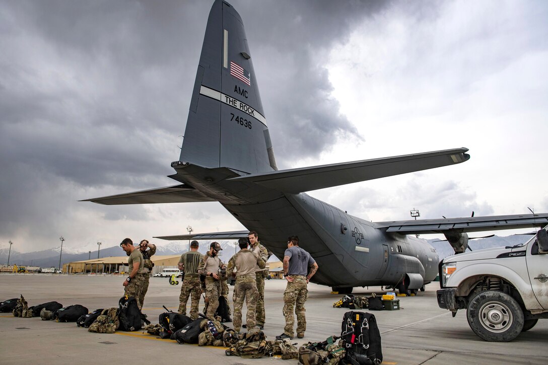 Airmen prepare their gear before boarding a C-130J Super Hercules.