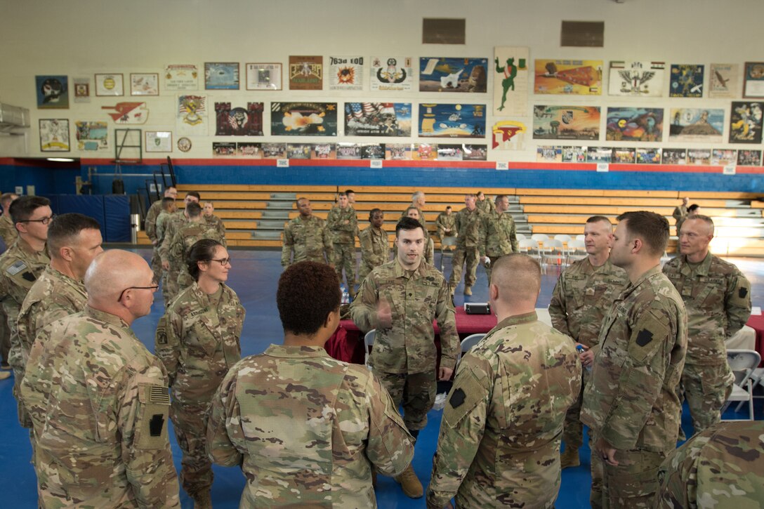 Retired Army Spc. Justin Lane, center, speaks to 28th Infantry Division soldiers at Camp Arifjan, Kuwait,