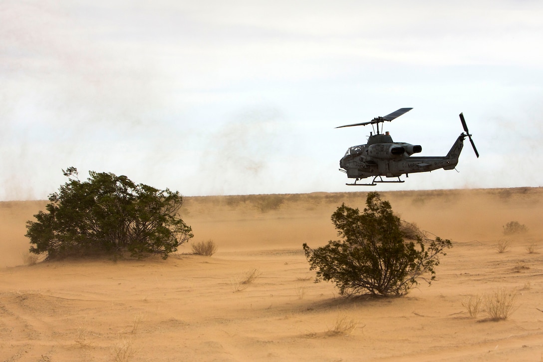 Marine Corps aviators fly an AH-1 Cobra helicopter.