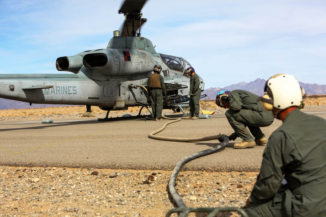 Marines refuel an AH-1 Cobra helicopter.