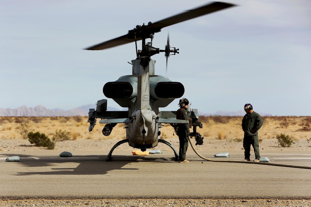 Marines refuel an AH-1 Cobra helicopter.