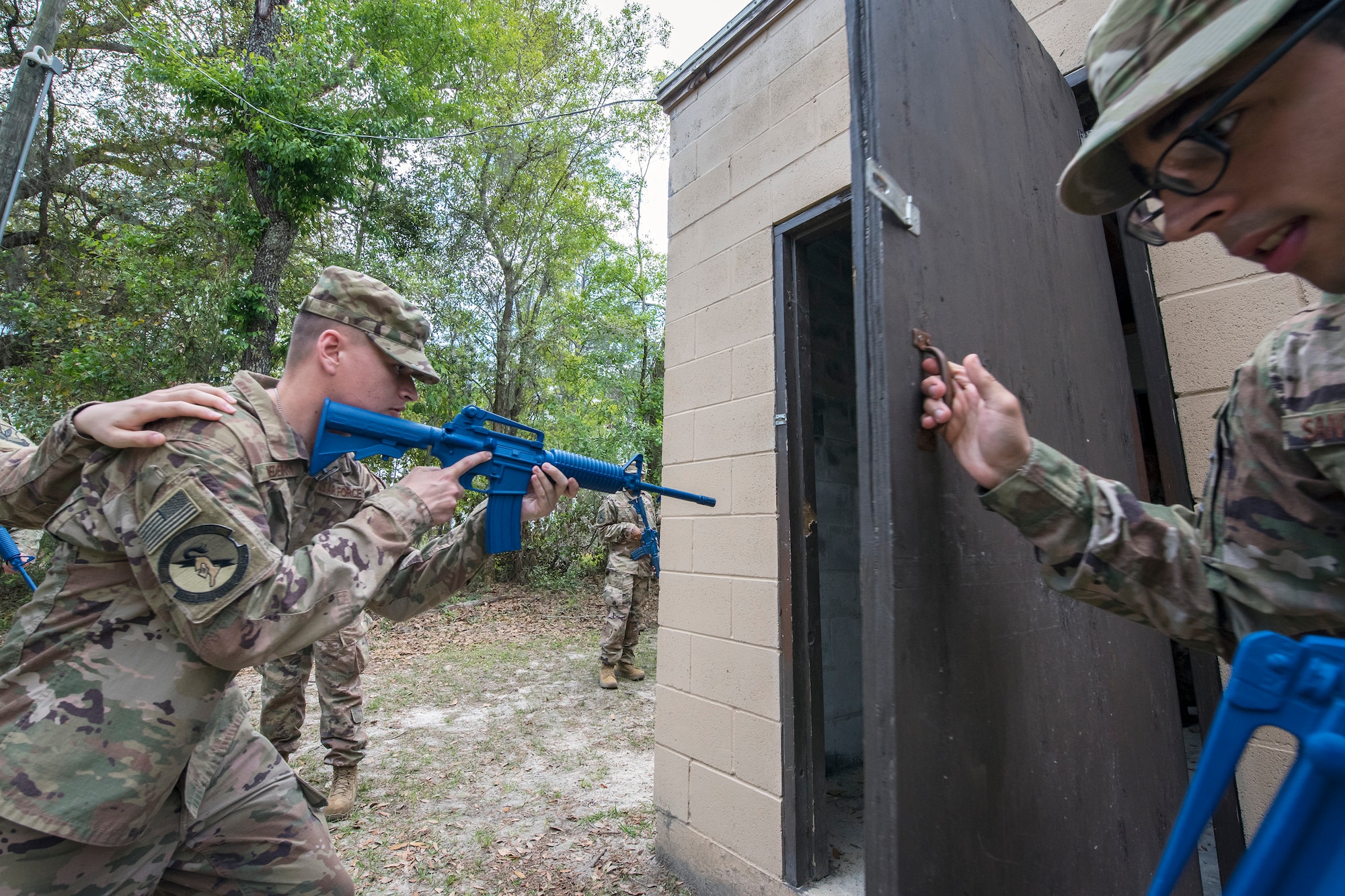 Airmen 1st Class David Medeiros, 824th Base Defense Squadron fireteam member, left, prepares to enter a building during dismounted operations training, March 27, 2018, at Moody Air Force Base, Ga. The dismounted ops training is part of an Initial Qualification Training, which gives new Airmen coming into the 820th Base Defense Group an opportunity to learn a baseline of basic combat skills that will be needed to successfully operate within a cohesive unit while in a deployed environment. (U.S. Air Force photo by Airman Eugene Oliver)