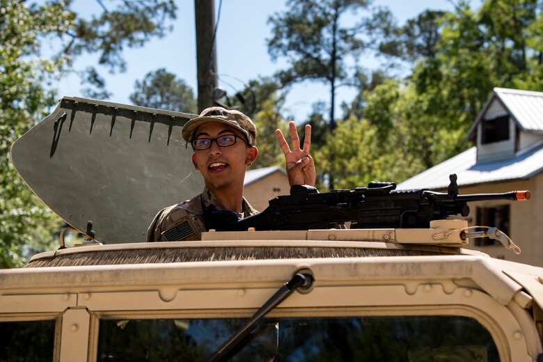 Airman Angel Rodriguez, 824th Base Defense Squadron, fireteam member signals to his other Airmen from the turret position of a Humvee during vehicle operations training, March 28, 2018, at Moody Air Force Base, Ga. The vehicle ops training is part of Initial Qualification Training, which gives new Airmen coming into the 820th Base Defense Group an opportunity to learn a baseline of basic combat skills that will be needed to successfully operate within a cohesive unit while in a deployed environment. (U.S. Air Force photo by Airman Eugene Oliver)