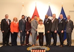 The Defense Acquisition University Senior Service College Fellowship Program participants pose with Hue Nguyen, center, DLA Troop Support flag room supervisor, at DLA Troop Support in Philadelphia April 3, 2018.