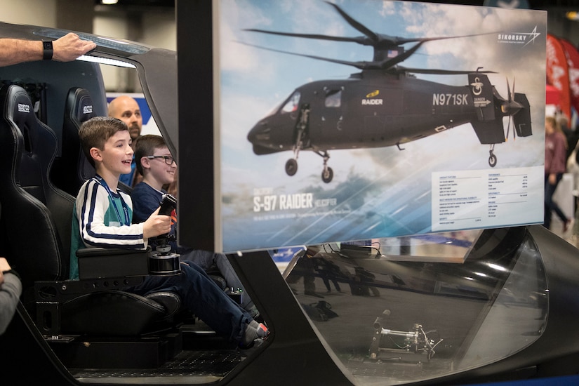 Jack Boren, left, and his brother Grant, pilot a helicopter simulator during the USA Science and Engineering Festival in Washington.