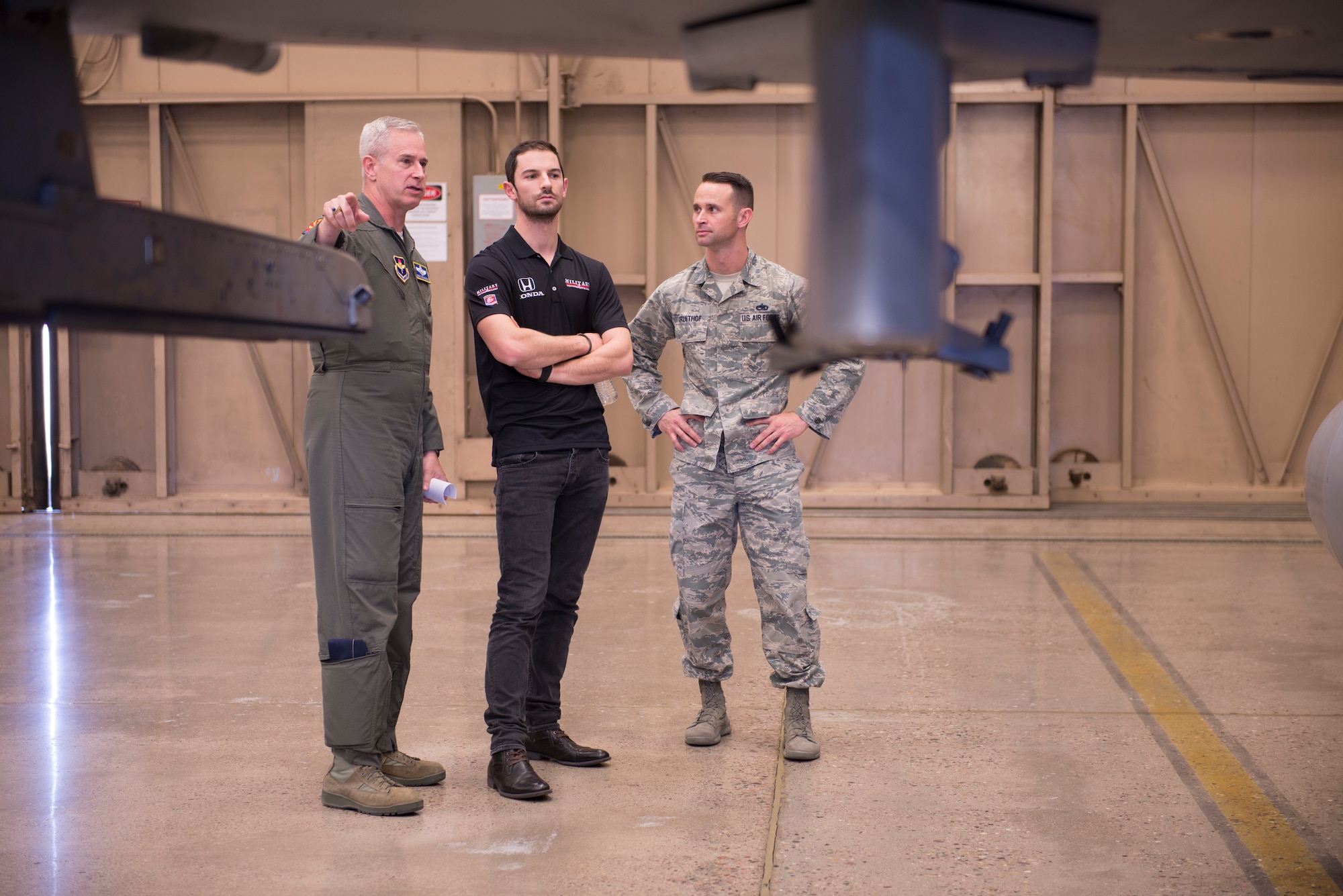 Col. Michael Richardson, 56th Fighter Wing vice commander; Alexander Rossi, Andretti Autosport racecar driver; and Master Sgt. Justin Kruithof, 56th Equipment Maintenance Squadron fabrication flight superintendent, talk about the F-16 Fighting Falcon and its capabilities at Luke Air Force Base, Ariz., April 5, 2018. Rossi, an Indycar racer, greeted Airmen at a variety of locations as he toured the base. (U.S. Air Force photo by Senior Airman Ridge Shan)