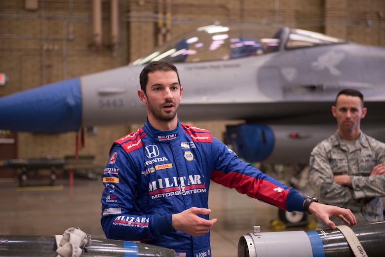 Alexander Rossi, Andretti Autosport racecar driver, asks questions about aircraft weapons to members of the 56th Maintenance Group during his visit to Luke Air Force Base, Ariz., April 5, 2018. His visit allowed Airmen a chance to meet the athlete and exchange details about their work and lives. (U.S. Air Force photo by Senior Airman Ridge Shan)