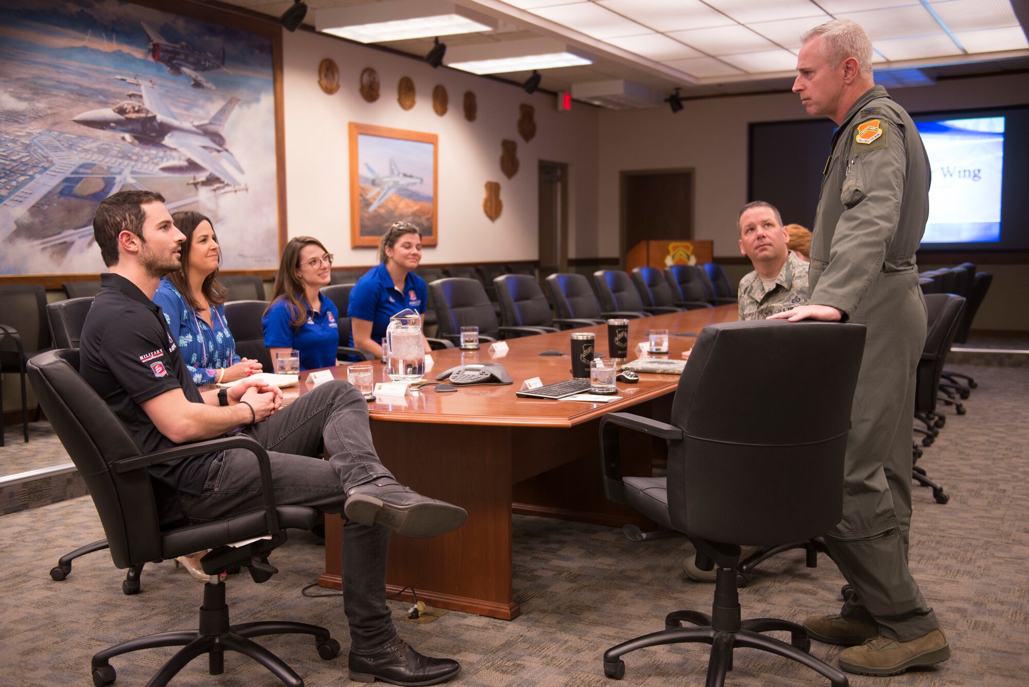 Col. Michael Richardson, 56th Fighter Wing vice commander, briefs members of the Andretti Autosport team on the wing mission at Luke Air Force Base, Ariz., April 5, 2018. The team toured the base and greeted Airmen. (U.S. Air Force photo by Senior Airman Ridge Shan)
