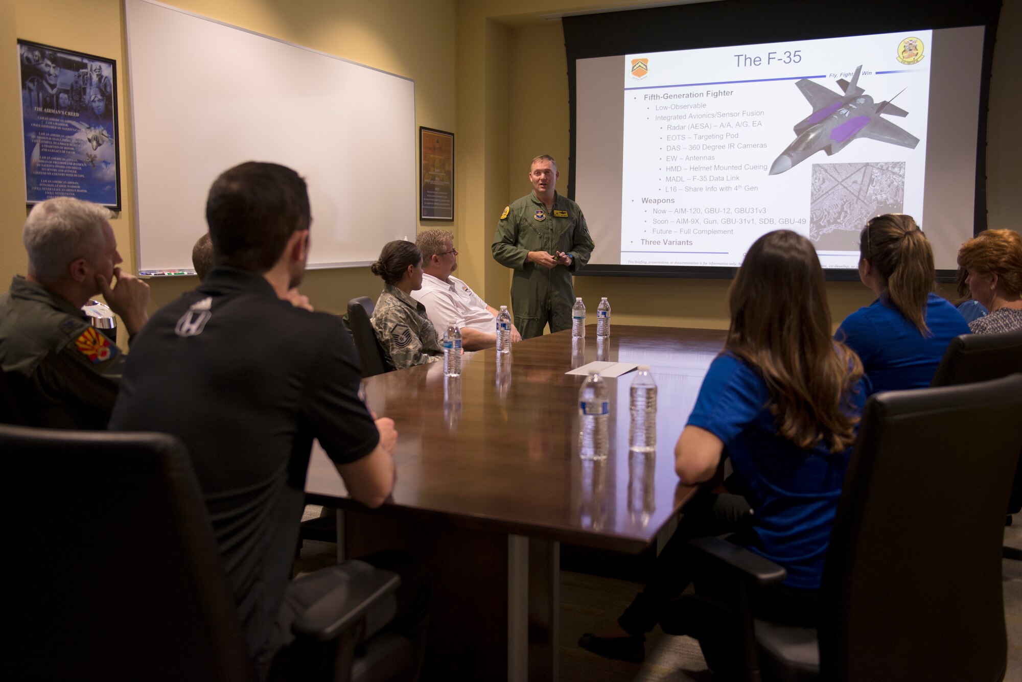 Lt. Col. Rhett Hierlmeier, 61st Fighter Squadron commander, briefs delegates from Andretti Autosport and members of Luke’s command team on the capabilities of the F-35 Lightning II at Luke Air Force Base, Ariz., April 5, 2018. The Andretti Autosport team, which included racecar driver Alexander Rossi , learned about the aircraft, mission, and Airmen at Luke. (U.S. Air Force photo by Senior Airman Ridge Shan)