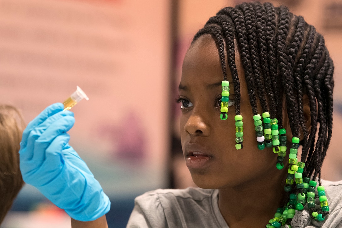Laila Jeanjulien, 9, observes a vial used in a science activity at the USA Science and Engineering Festival in Washington.