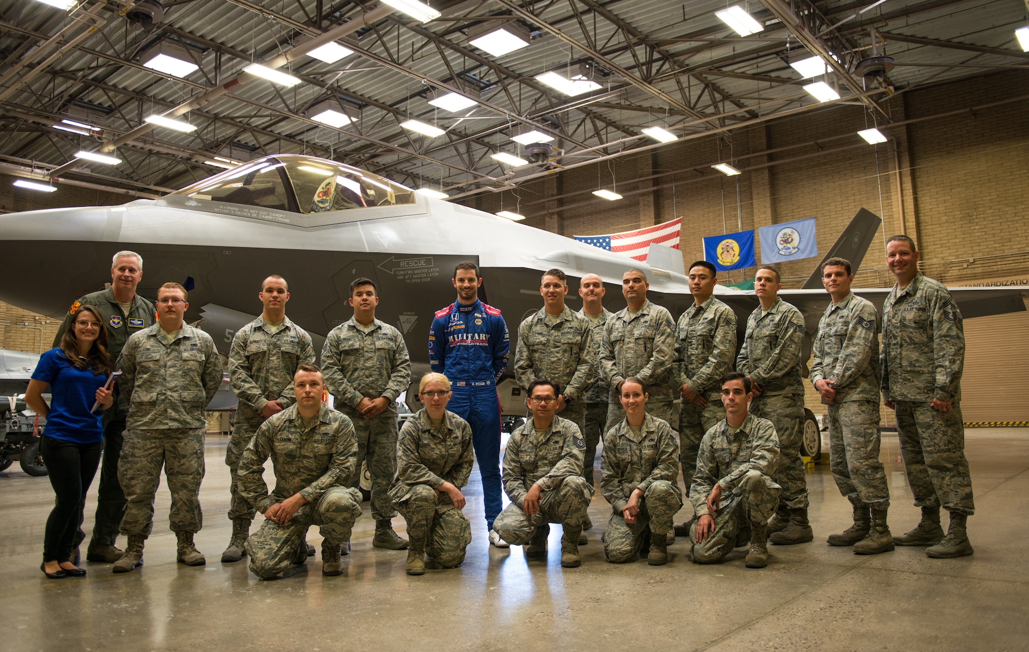 Alexander Rossi, Andretti Autosport team race car driver, poses for a group photo with Thunderbolts from the 61st Aircraft Maintenance Unit at Luke Air Force Base, Ariz., April 5, 2018. During their visit, Rossi and his team visited various units around base to gain insight on the mission of Luke and its Airmen. (U.S. Air Force photo by Airman 1st Class Alexander Cook)