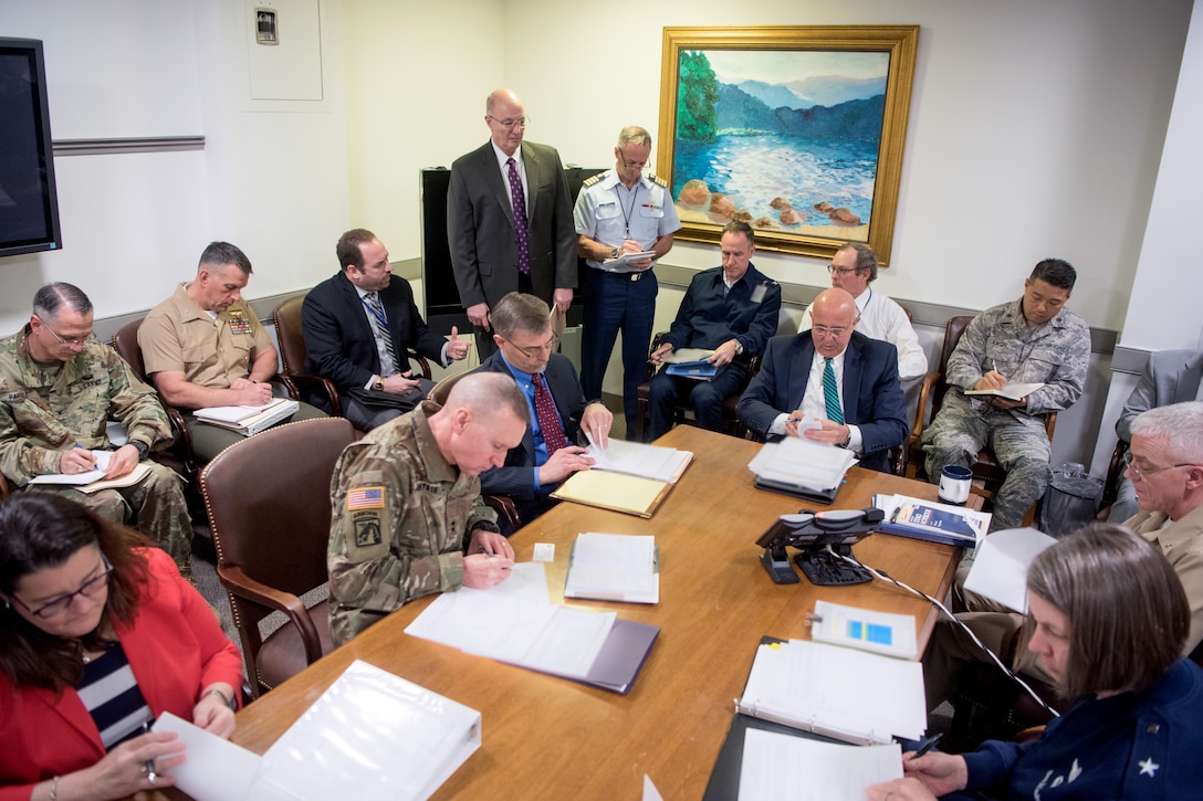 A group of people stand in a room.