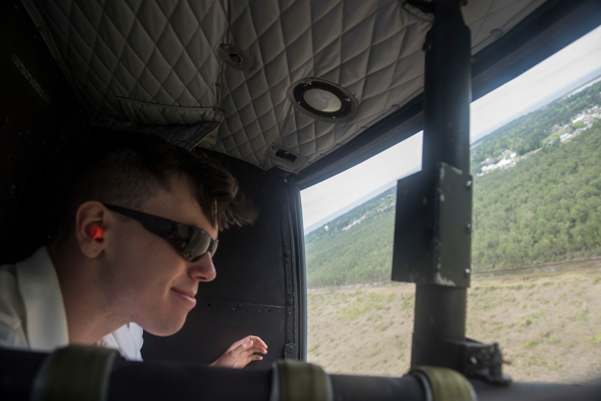 David Stewart, Auburn University Air Force ROTC cadet, looks out the doors of a TH-1H helicopter during an incentive flight during Pathways to Blue April 6, 2018, on Keesler Air Force Base, Mississippi. Throughout the two-day event, ROTC cadets and enlisted personnel traveled through this diverse and inclusive event to better aim themselves to become future Air Force leaders. The event provided more than 280 cadets from 15 different colleges and universities a chance to receive hands-on demonstrations of various career fields. (U.S. Air Force photo by Senior Airman Travis Beihl)