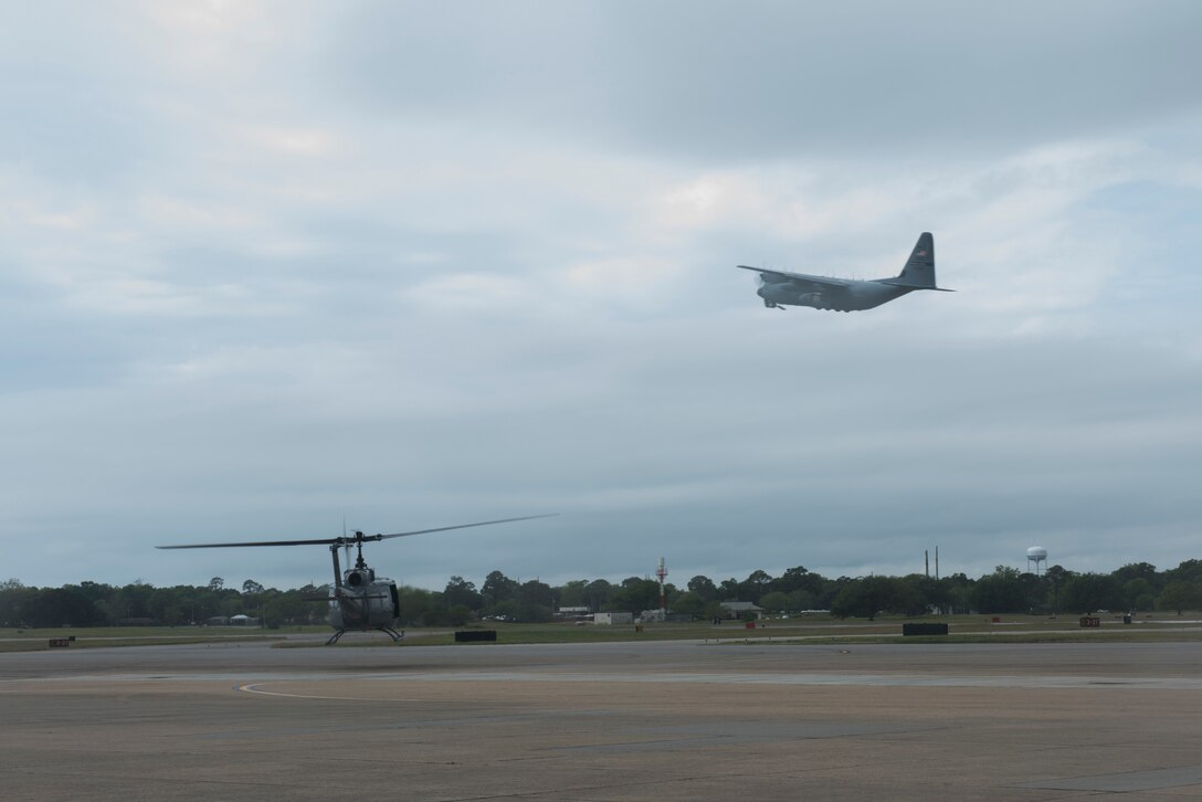 A TH-1H helicopter and MC-130 Commando II take off for incentive flights during Pathways to Blue April 6, 2018, on Keesler Air Force Base, Mississippi. Cadets received an orientation flight along with hands-on briefings on technical and flying operations in support of the Air Force’s Diversity Strategic Roadmap program. The event provided more than 280 cadets from 15 different colleges and universities a chance to receive hands-on demonstrations of various career fields. (U.S. Air Force photo by Senior Airman Travis Beihl)