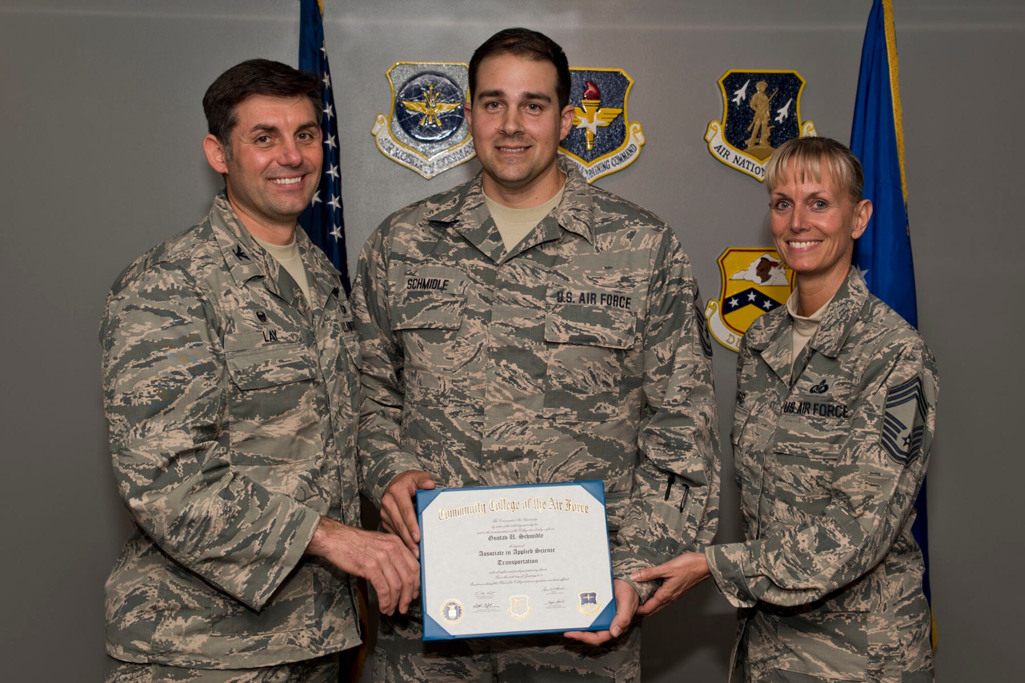 U.S. Air Force Reserve Master Sgt. Gustav Schmidle, air transportation, 96th Arial Port Squadron, poses for a photo with Col. Christopher Lay, the 913th Airlift Group commander, and Chief Master Sgt. Kimberly Lord, superintendent, 913th AG, after an All Call, April 7, 2018, at Little Rock Air Force Base, Ark. Schmidle received an Associate in Applied Science Transportation degree from the Community College of the Air Force. (U.S. Air Force photo by Master Sgt. Jeff Walston)