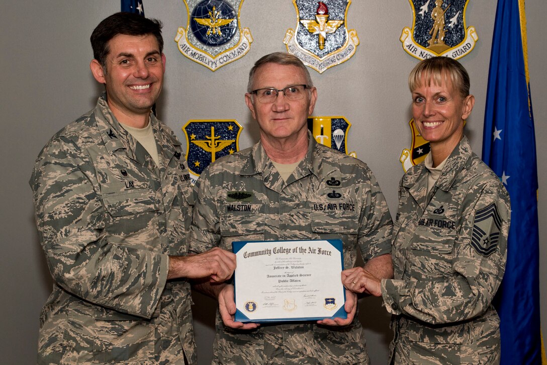 U.S. Air Force Reserve Master Sgt. Jeff Walston, the 913th Airlift Group’s public affairs technician, poses for a photo with Col. Christopher Lay, the 913th AG commander, and Chief Master Sgt. Kimberly Lord, superintendent, 913th AG, after an All Call, April 7, 2018, at Little Rock Air Force Base, Ark. Walston received an Associate in Applied Science Public Affairs degree from the Community College of the Air Force. (U.S. Air Force photo by Capt. Casey Staheli)