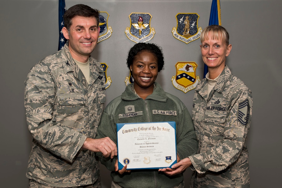 U.S. Air Force Reserve Master Sgt. Quenette Freeman, noncommissioned officer in charge, Equal Opportunity, 913th Airlift Group, poses for a photo with Col. Christopher Lay, the 913th AG commander, and Chief Master Sgt. Kimberly Lord, superintendent, 913th AG, after an All Call, April 7, 2018, at Little Rock Air Force Base, Ark. Freeman received an Associate in Applied Science Human Services degree from the Community College of the Air Force. (U.S. Air Force photo by Master Sgt. Jeff Walston)