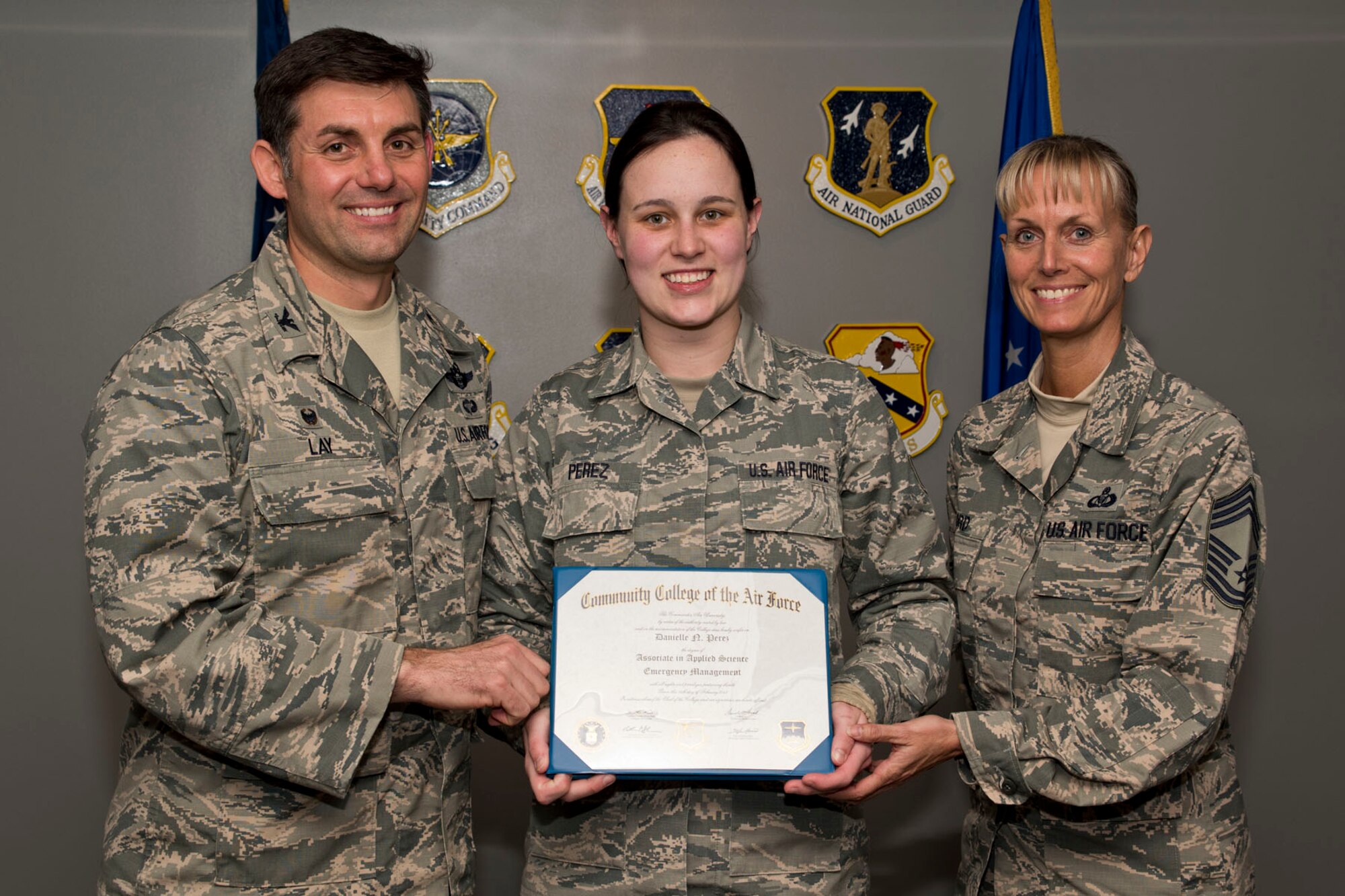 U.S. Air Force Reserve Staff Sgt. Danielle Perez, noncommissioned officer in charge, Commanders Support Staff, 327th Airlift Squadron, poses for a photo with Col. Christopher Lay, the 913th Airlift Group commander, and Chief Master Sgt. Kimberly Lord, superintendent, 913th AG, after an All Call, April 7, 2018, at Little Rock Air Force Base, Ark. Perez received an Associate in Applied Science Emergency Management degree from the Community College of the Air Force. (U.S. Air Force photo by Master Sgt. Jeff Walston)
