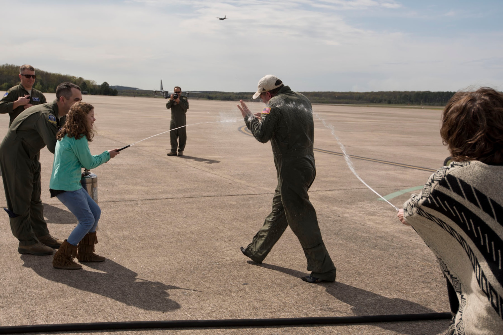U.S. Air Force Reserve Maj. Claude Smith, chief of current operations, 913th Operations Support Squadron, is congratulated by his daughter Anna Claire and mother Vide Waller with the traditional wet down after his fini-flight April 5, 2018, at Little Rock Air Force Base, Ark. The sortie was his last in a C-130J before retiring from the Air Force Reserve after 28 years of faithful military service. (U.S. Air Force photo by Master Sgt. Jeff Walston)