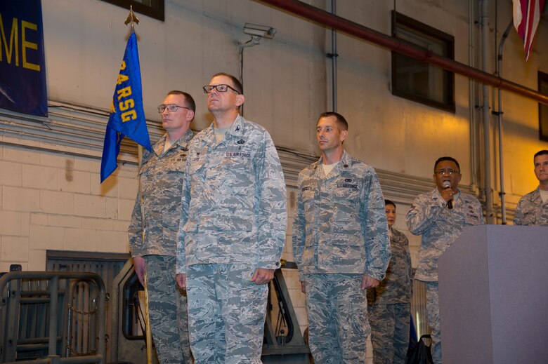 U.S. Air Force Senior Master Sgt. Steven Martin, 48th Aerial Port Squadron first sergeant, Col. Kenneth Lute, 624th Regional Support Group commander, and Maj. Kenneth Ruggles Jr. stand at attention for the national anthem during the 48th Aerial Port Squadron’s assumption of command ceremony at Joint Base Pearl Harbor-Hickam, Hawaii, April 7, 2018, where Ruggles will become the new squadron commander.