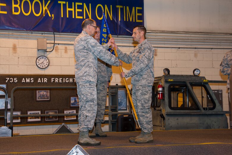 U.S. Air Force Col. Kenneth Lute, 624th Regional Support Group commander, gives Maj. Kenneth Ruggles Jr. command of the 48th Aerial Port Squadron during an assumption of command ceremony at Joint Base Pearl Harbor-Hickam, Hawaii, April 7, 2018.