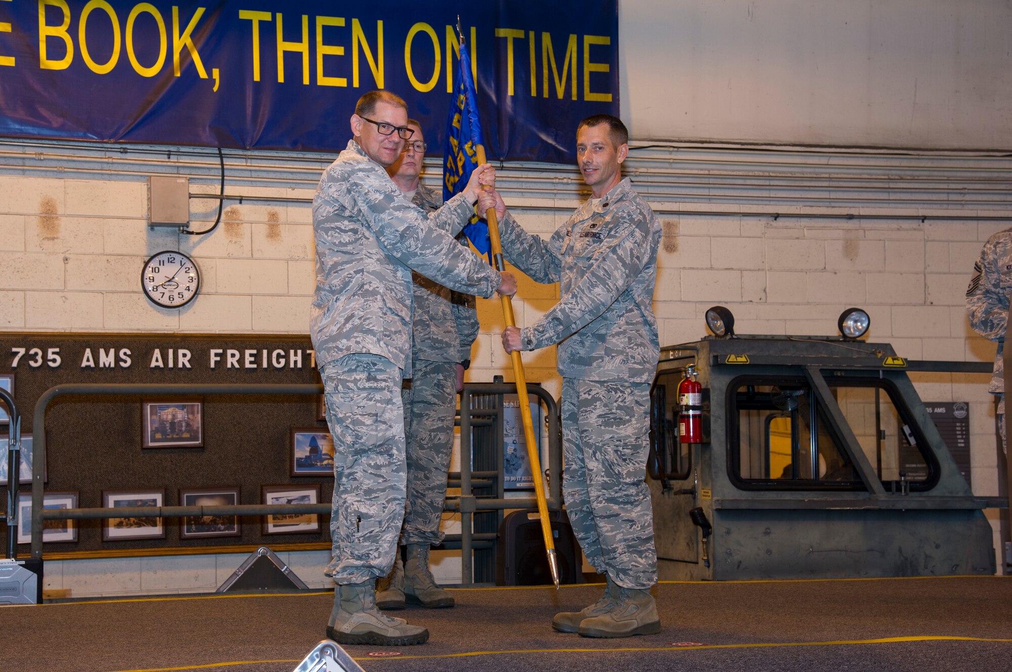 U.S. Air Force Col. Kenneth Lute, 624th Regional Support Group commander, gives Maj. Kenneth Ruggles Jr. command of the 48th Aerial Port Squadron during an assumption of command ceremony at Joint Base Pearl Harbor-Hickam, Hawaii, April 7, 2018.