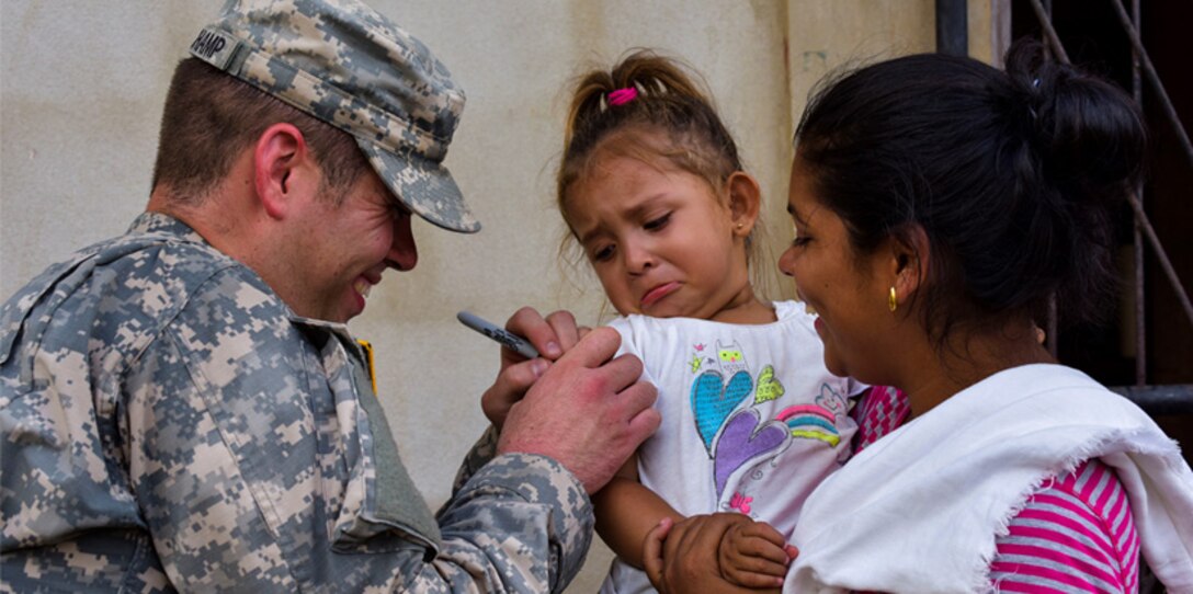 An Army medic prepares a little girl for treatment.