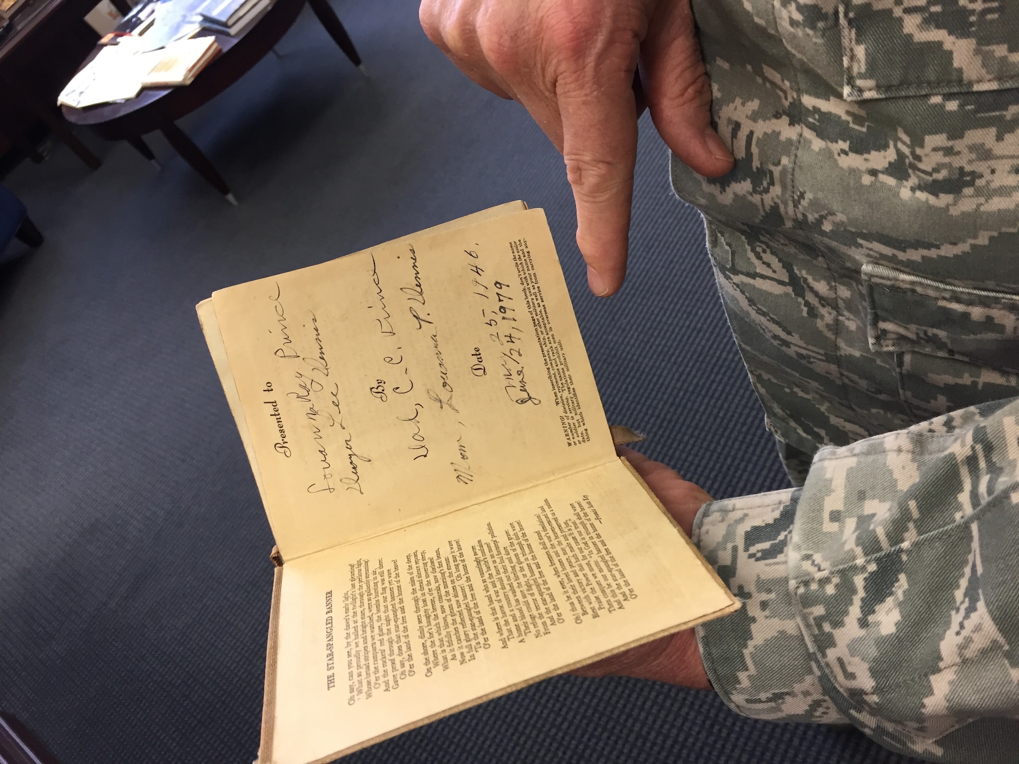 Maj. Gen. Dwyer Dennis, program executive officer for the Command, Control, Communications, Intelligence and Networks Directorate at Hanscom Air Force Base, Mass., holds a daily prayer devotionals in his office, April 6, 2018. The devotional belonged to his maternal grandfather, who was a U.S. Army Chaplain during World War II, serving in both theaters. Dennis is set to retire April 13 after serving 35 years as a U.S. Air Force officer. (U.S. Air Force Photo by Benjamin Newell)